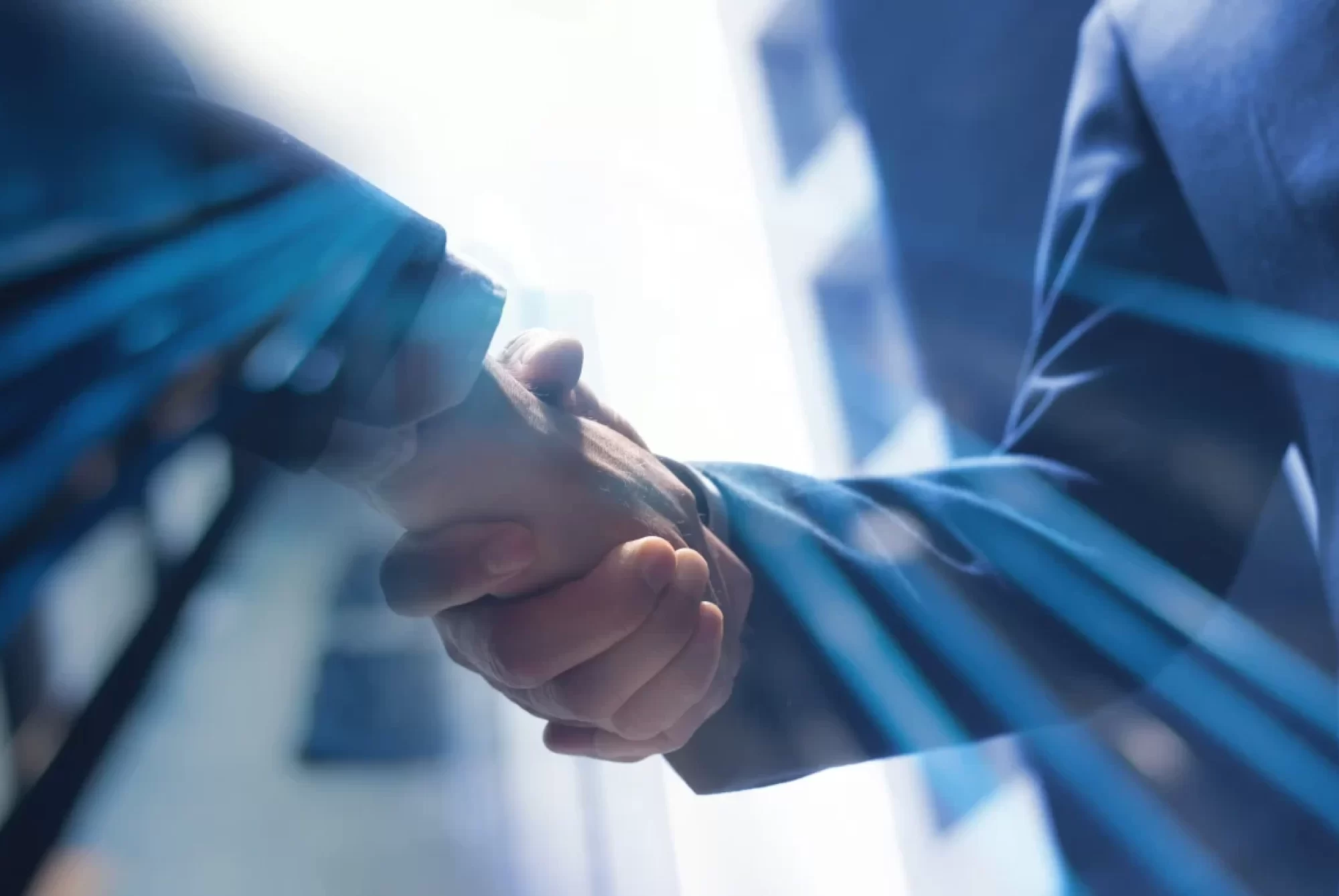 Stretta di mano tra due persone in un contesto aziendale con sfondo futuristico.