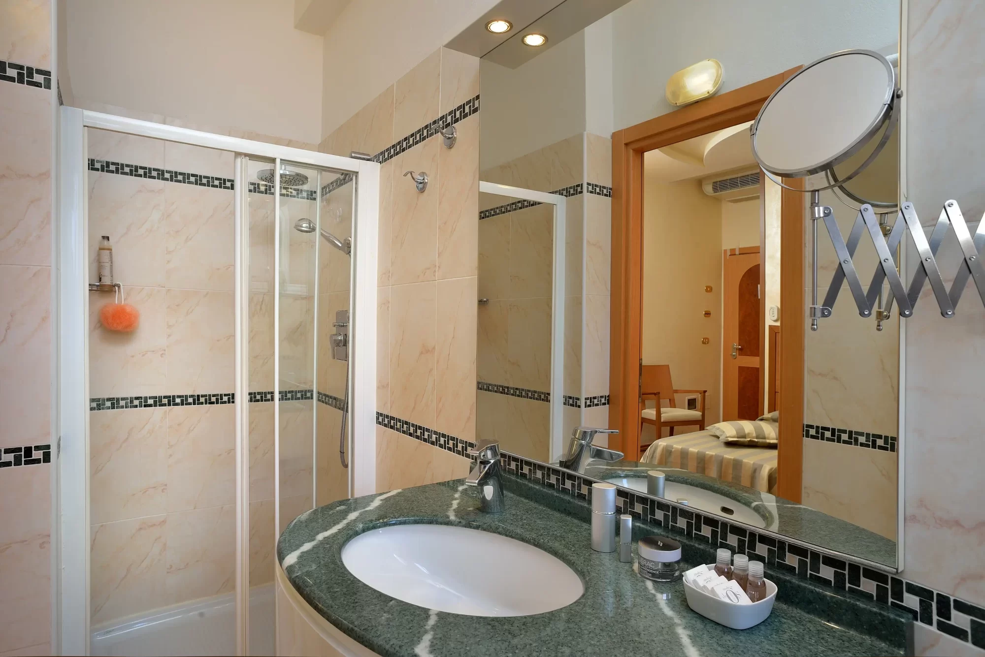 Bagno moderno con doccia in vetro e specchio sopra il lavandino.