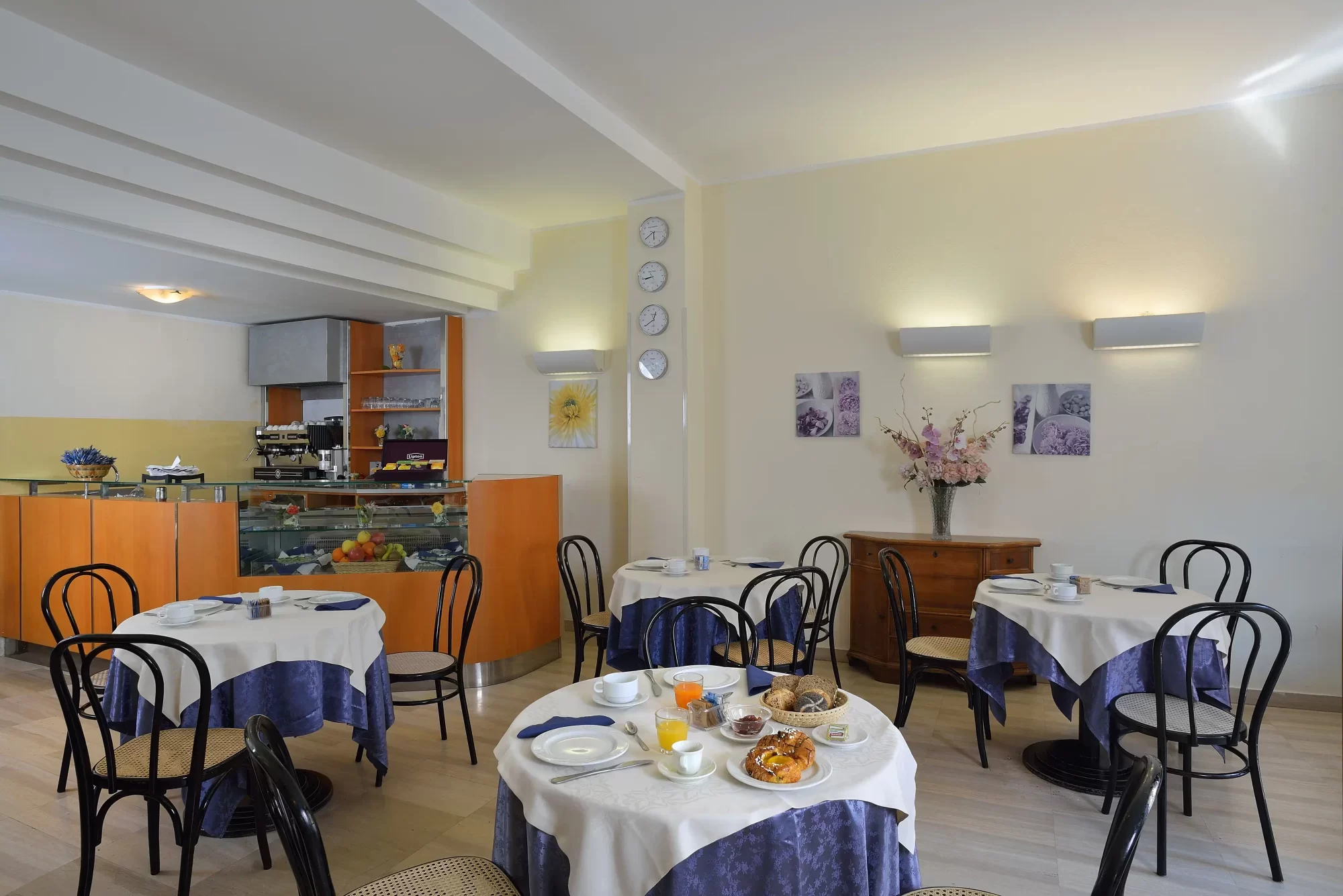 Sala da colazione elegante con tavoli apparecchiati e bancone di servizio.
