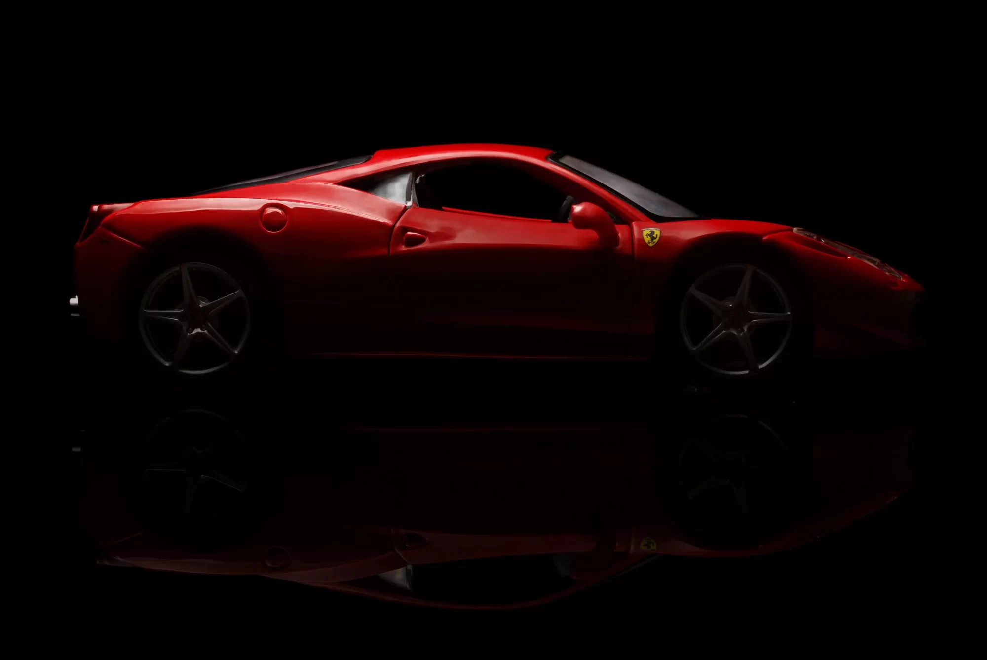 Auto sportiva rossa su sfondo nero.